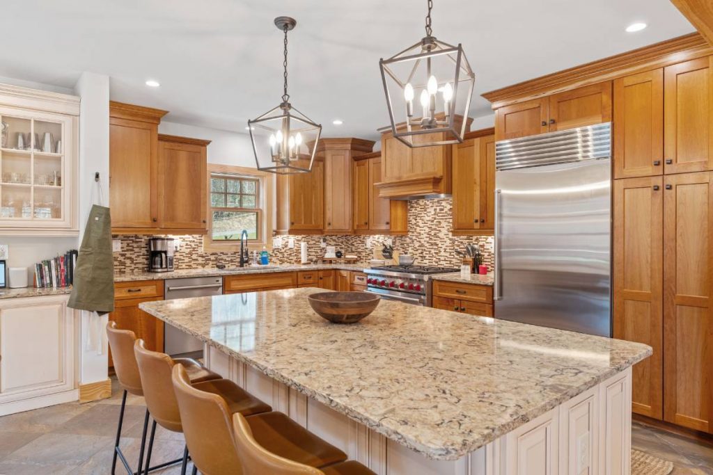 A modern kitchen with a granite island countertop and wooden cabinetry.