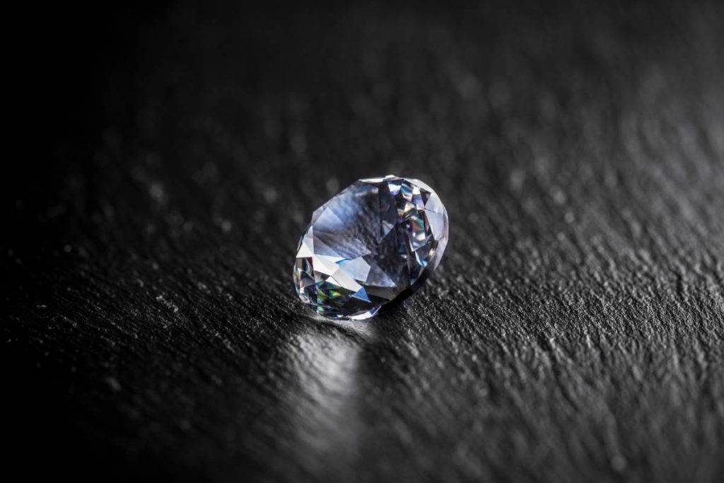 Shiny diamond on dark metal surface
