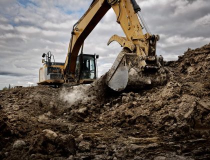 An excavator digging into the ground with its large bucket