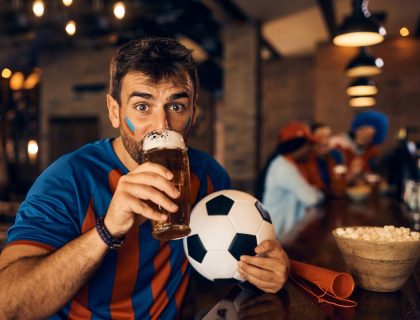 young-soccer-fan-holding-a-ball-and-drinking-beer-2024-12-13-21-46-29-utc (1)