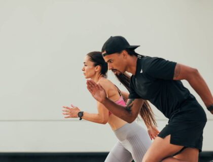 Side view of male and female runner exercising together at the wall
